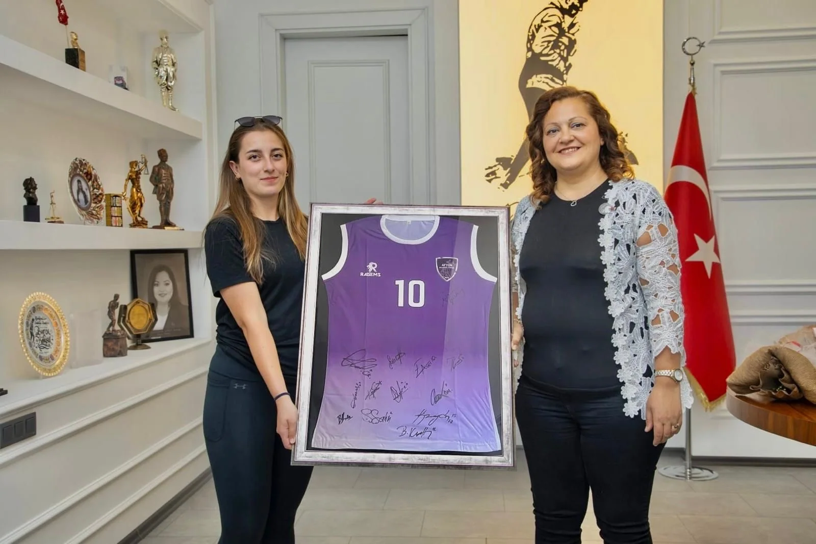 Baş antrenör Esma Özsoy, Belediye Başkanı Burcu Köksal'a imzalı forma takdim ederken